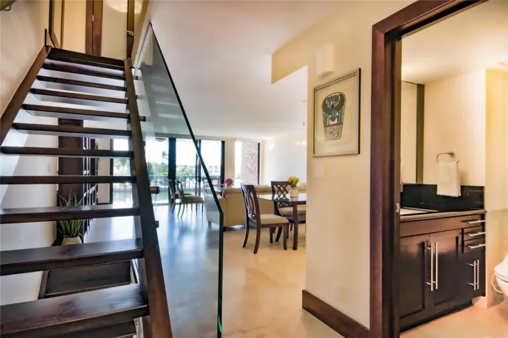 View of the entry way with the stairs going to the third and the second levels, powder room on the right.