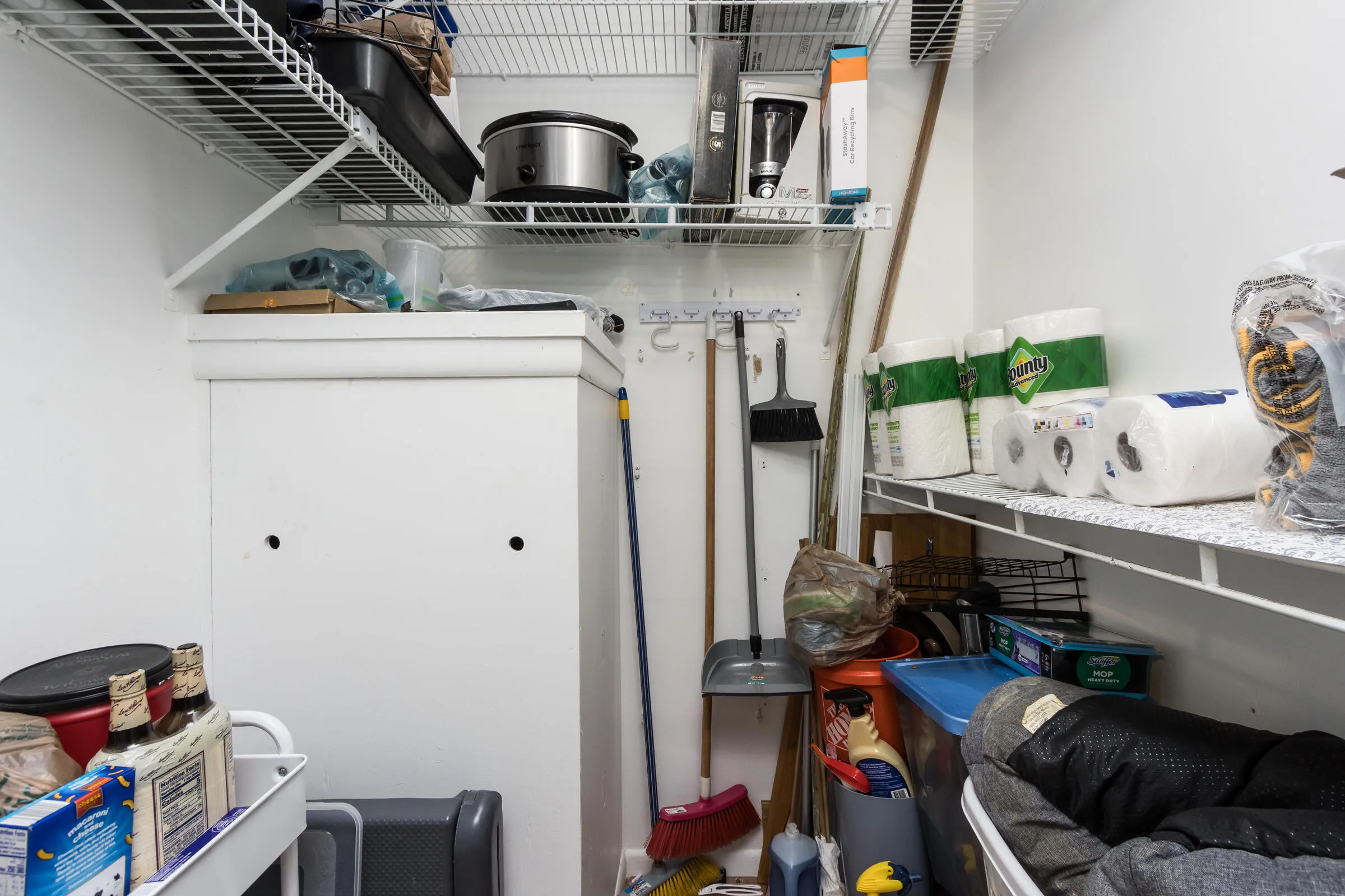 Walk-in closet in 2nd bedroom with storage and water heater.