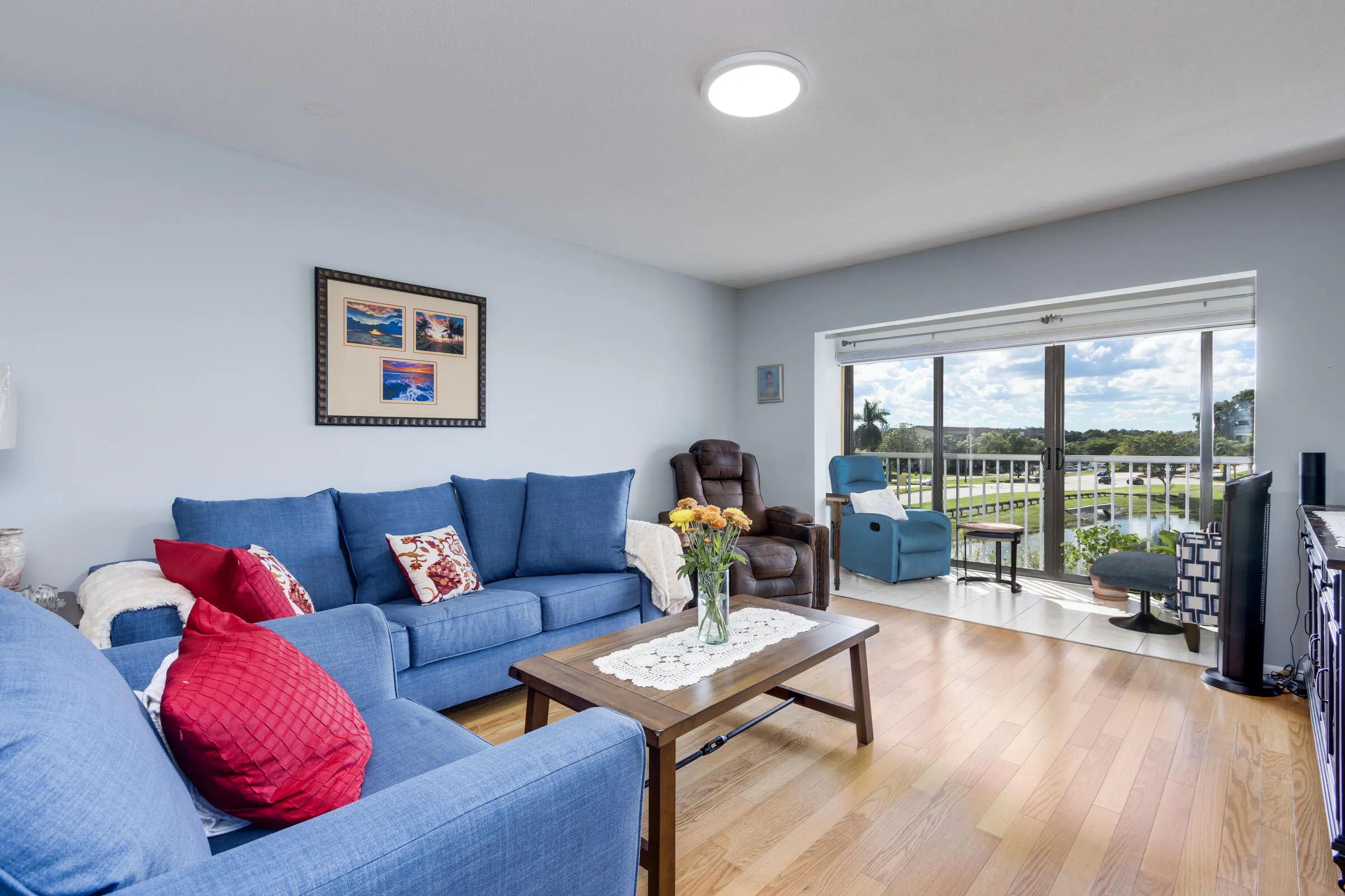 Living area with extended glass-in balcony includes hurricane impact windows & motorized shades.