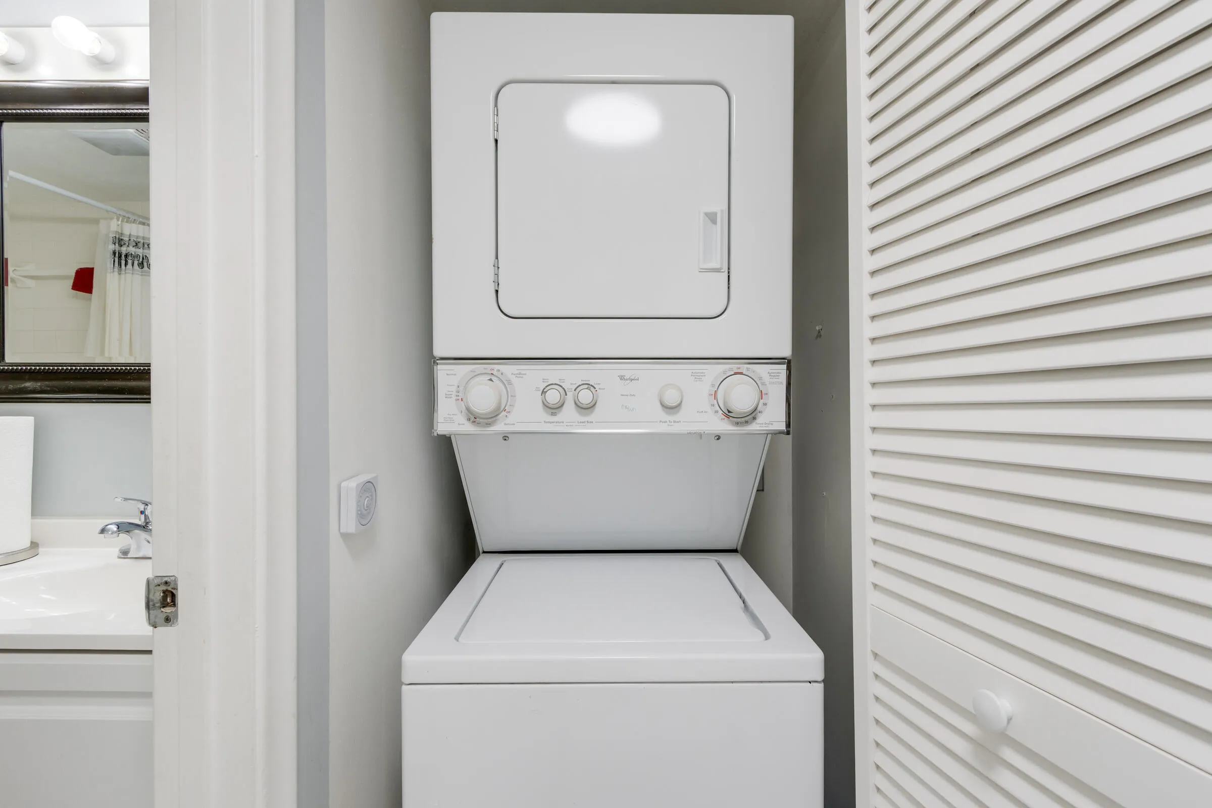 Conveniently located laundry closet with stackable washer & dryer.
