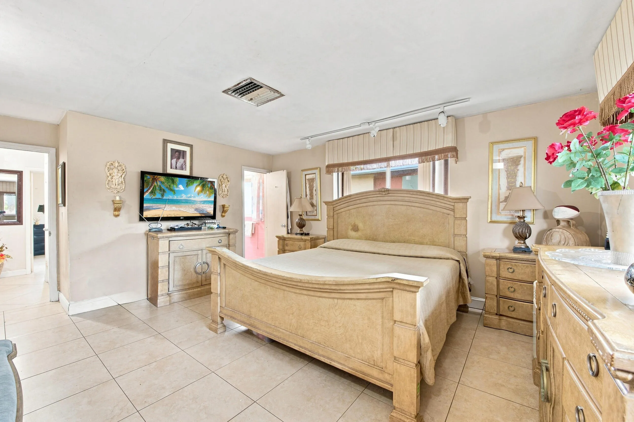 Spacious interior featuring tile flooring, neutral wall tones, window treatments, and recessed lighting