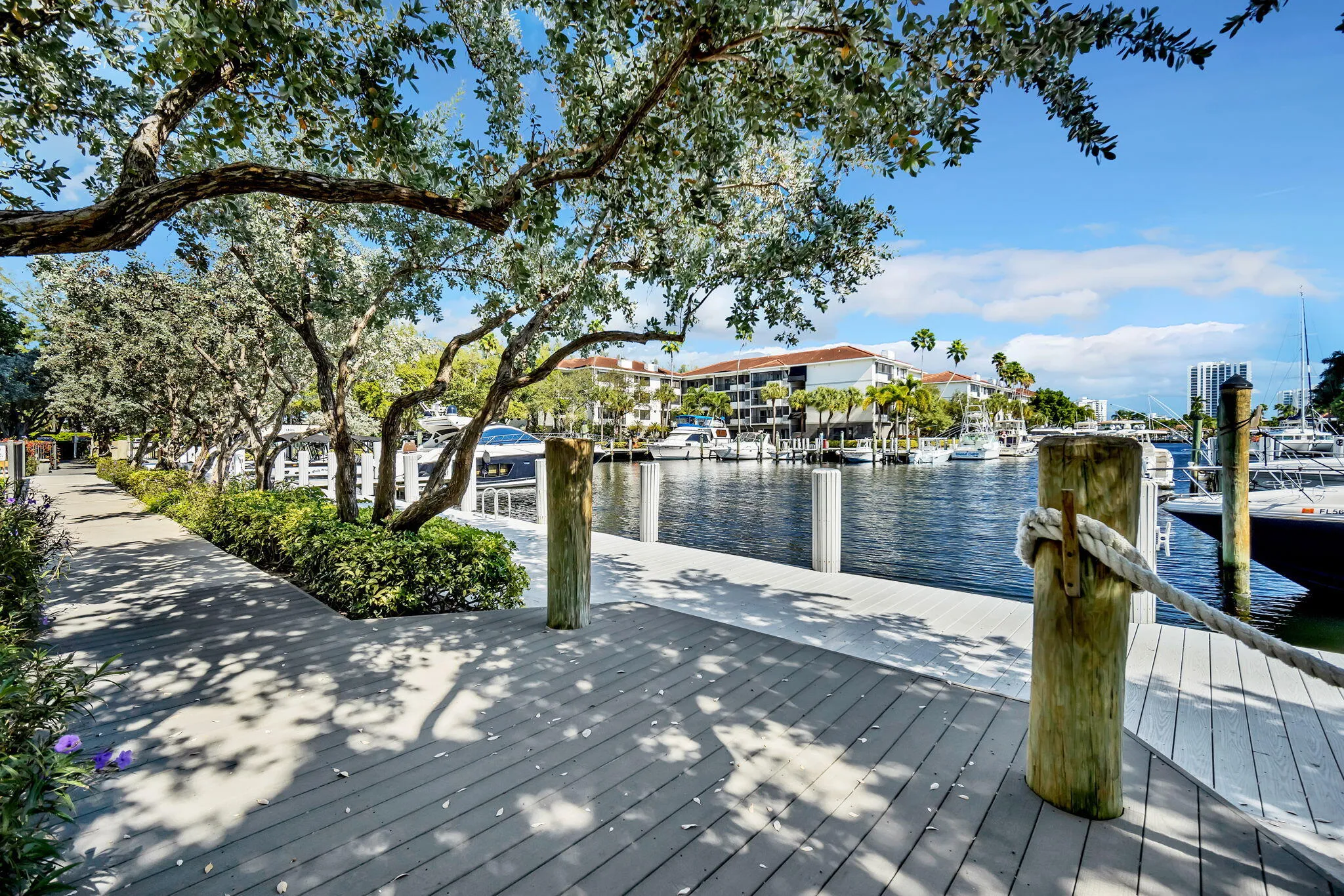 Waterfront boardwalk with a marine rope railing and multiple boat slips