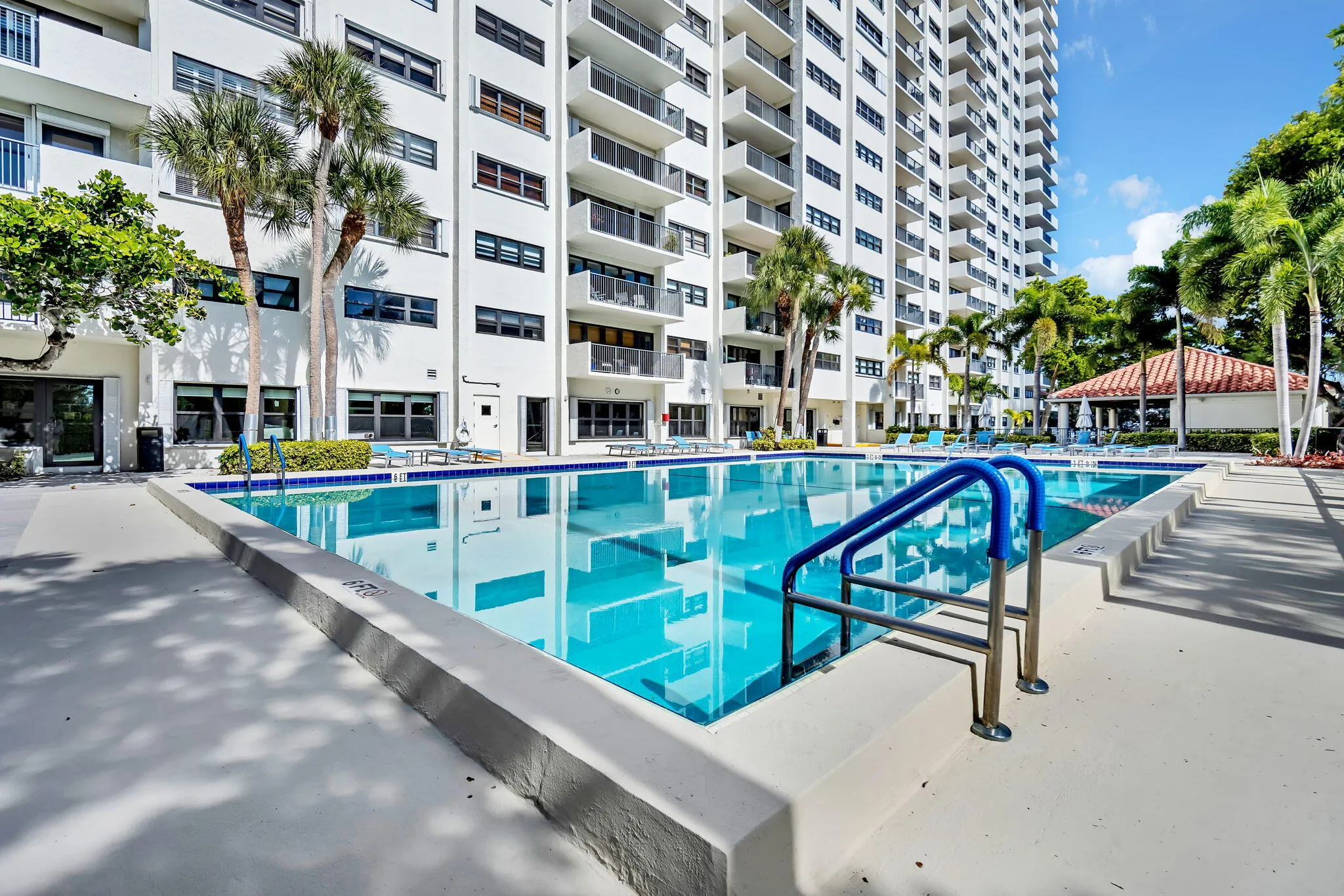 Expansive outdoor swimming pool with integrated entry steps and perimeter tiling