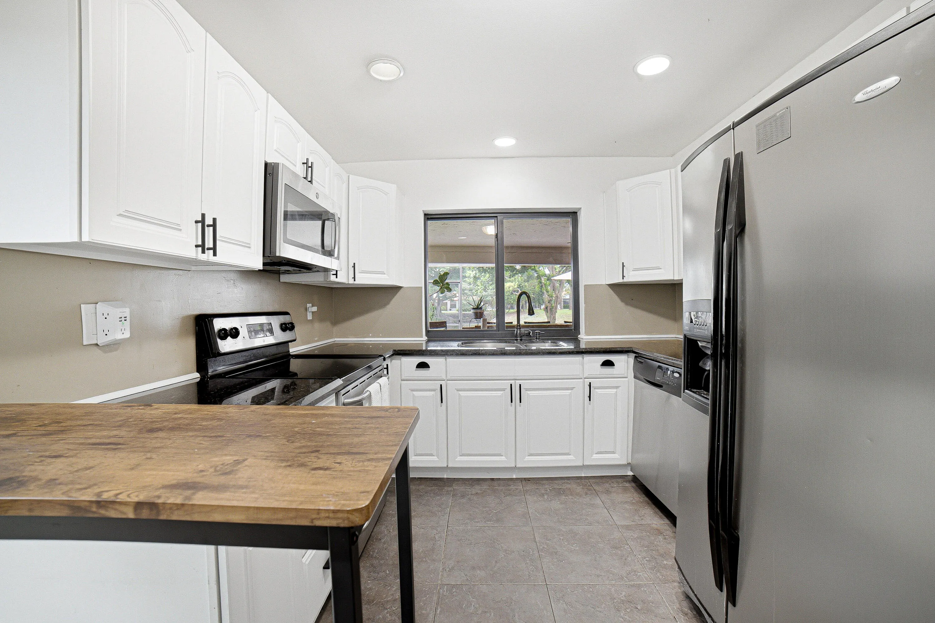 A very functional kitchen with exit to the garage where laundry can be found.