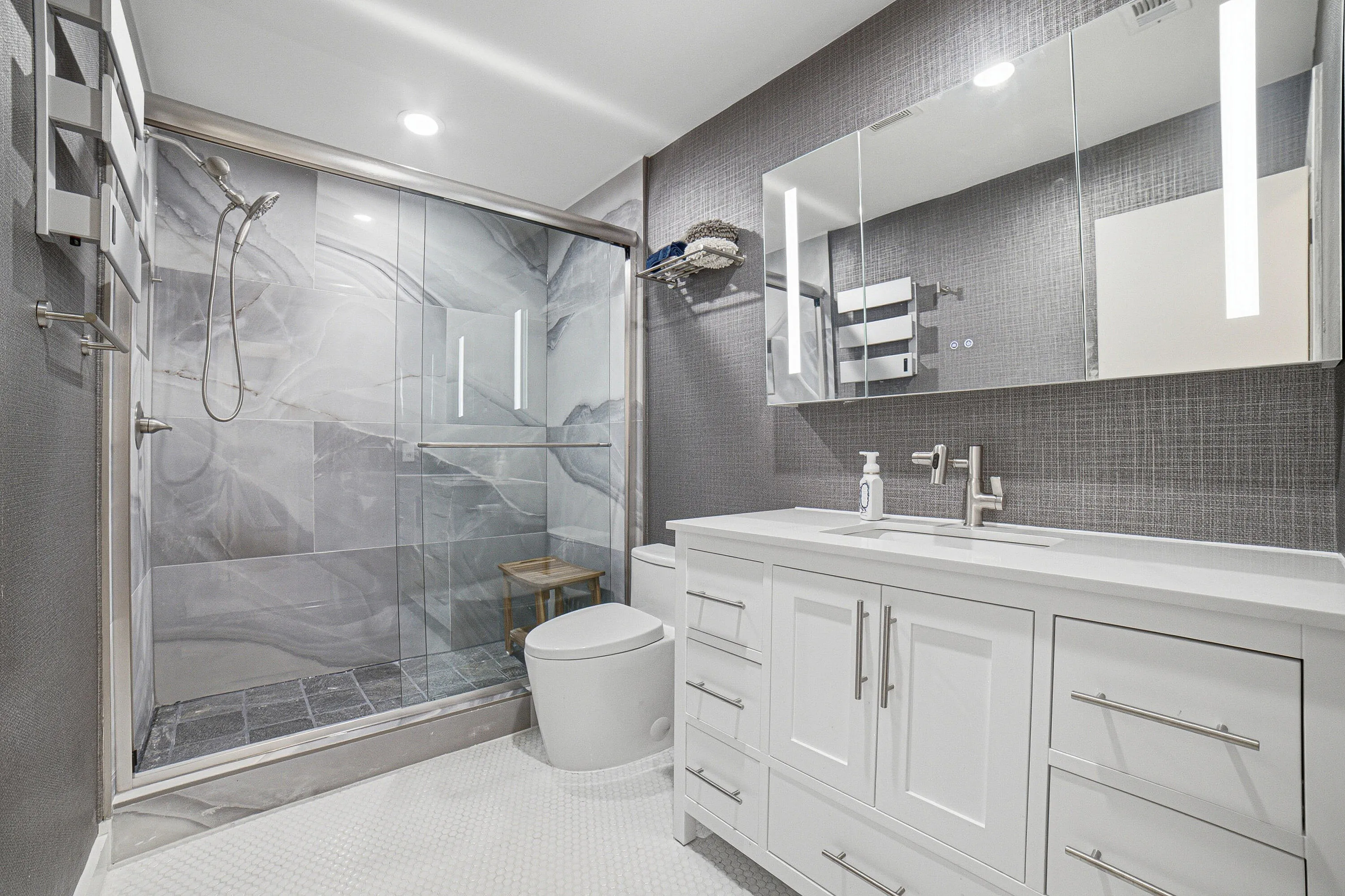 The guest bath offers a high-quality 48 inch solid wood vanity with white quartz top, a 48" LED medicine cabinet, a new syphonic action skirted toilet, an electric towel warmer and filtered shower head with a second 10 foot handheld showerhead.