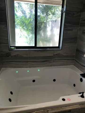 The jetted tub and huge shower has red, blue and green mood lighting for bathing.