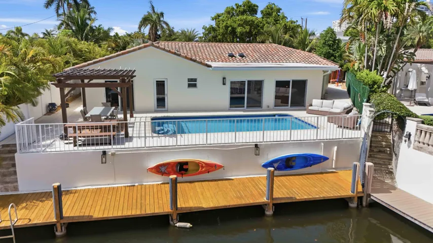 Bermuda-Riviera Waterfront property featuring a private boat dock, pool, and pergola-covered patio