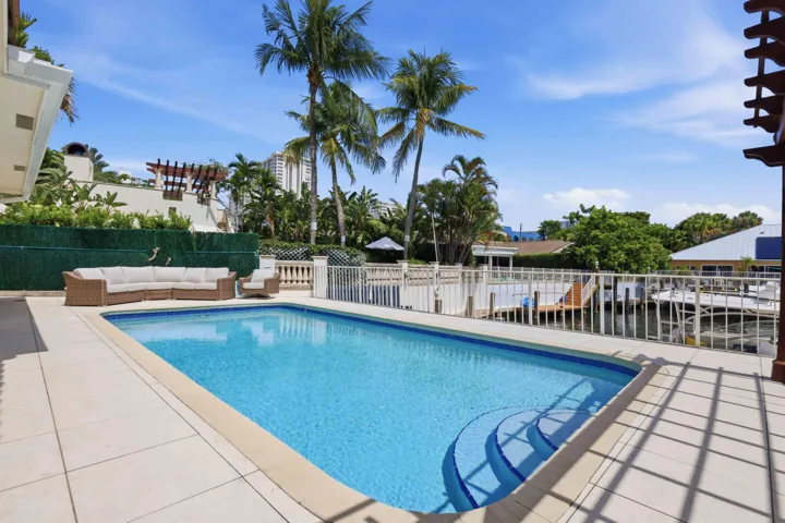 Outdoor swimming pool with integrated steps and a light-toned paved patio