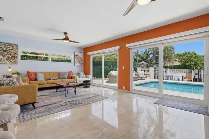 Spacious interior featuring reflective tile flooring, two ceiling fans, and an accent wall