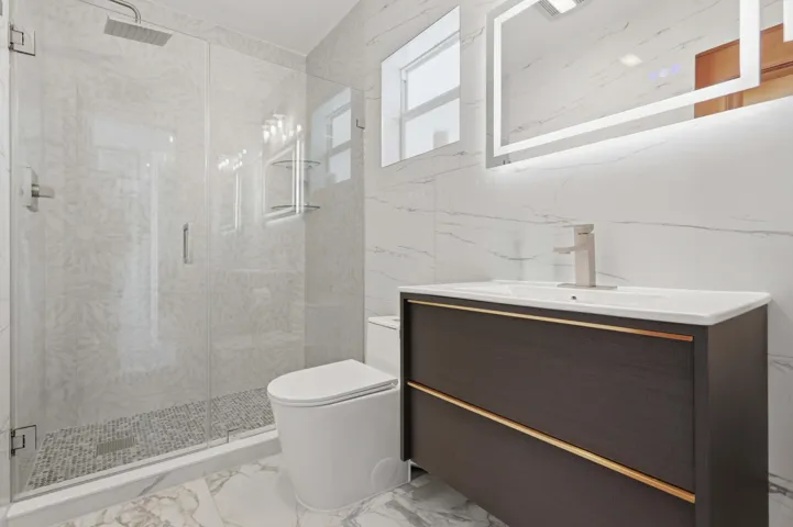Contemporary bathroom featuring a spacious glass-enclosed shower with a rainfall showerhead and mosaic tile flooring