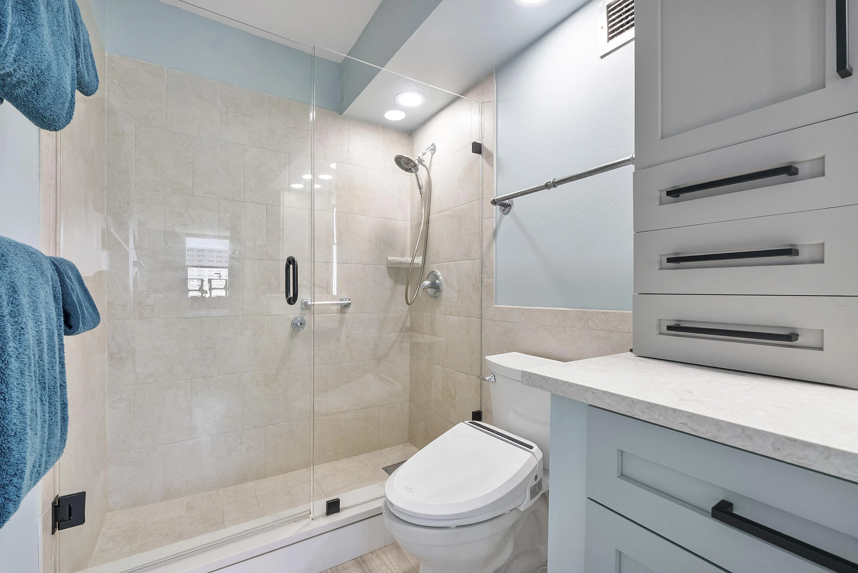 The master bathroom has a wide newer modern shower a special bidet toilet seat,with lots of storage and a special bidet toilet seat