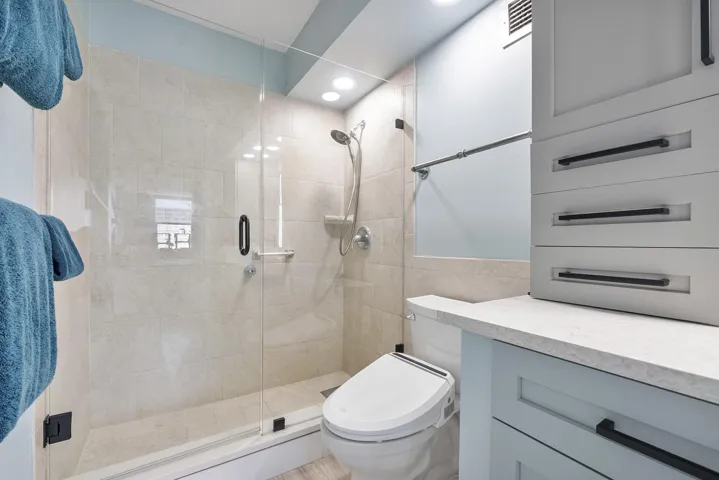 The master bathroom has a wide newer modern shower a special bidet toilet seat,with lots of storage and a special bidet toilet seat