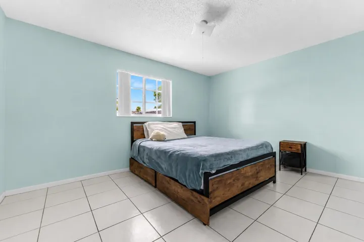 Light blue walls with a single window featuring horizontal blinds
