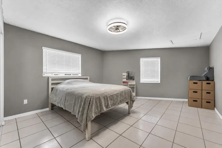 Room featuring neutral gray walls and white tile flooring