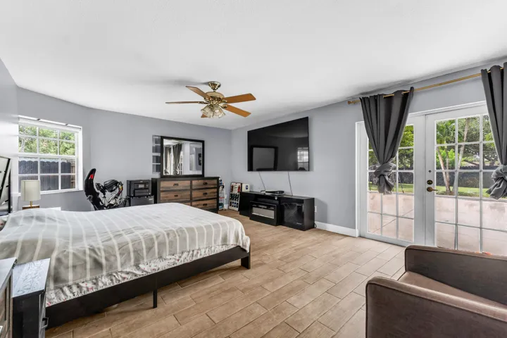 Spacious interior with wood-finish flooring, light gray walls, and a ceiling fan