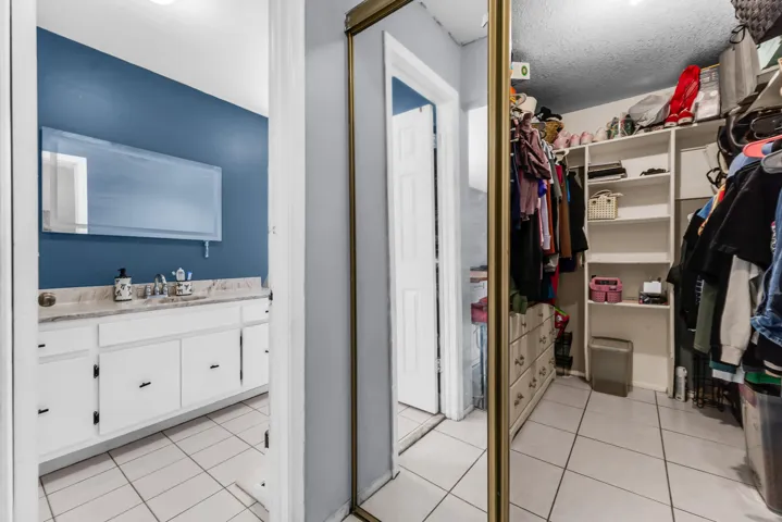 Walk-in closet featuring extensive built-in shelving, integrated drawers, and ample hanging storage