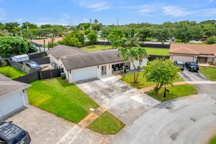 Single-story residence featuring a two-car garage, mature landscaping, and a fenced side yard