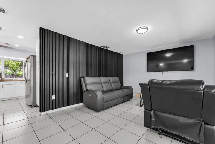 Interior space featuring light-colored square tile flooring and a distinctive black slatted accent wall