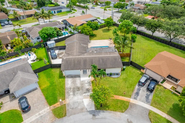 Single-story residence featuring a two-car garage, a concrete driveway, and a fenced backyard with a swimming pool