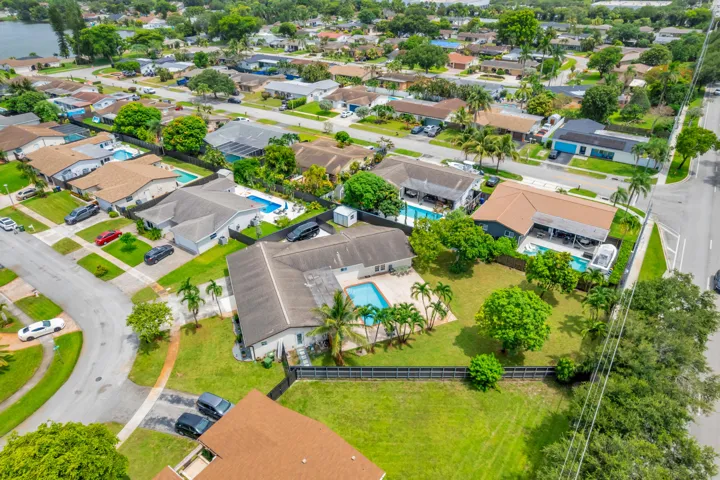 Aerial view showcasing a residential neighborhood with properties featuring private swimming pools