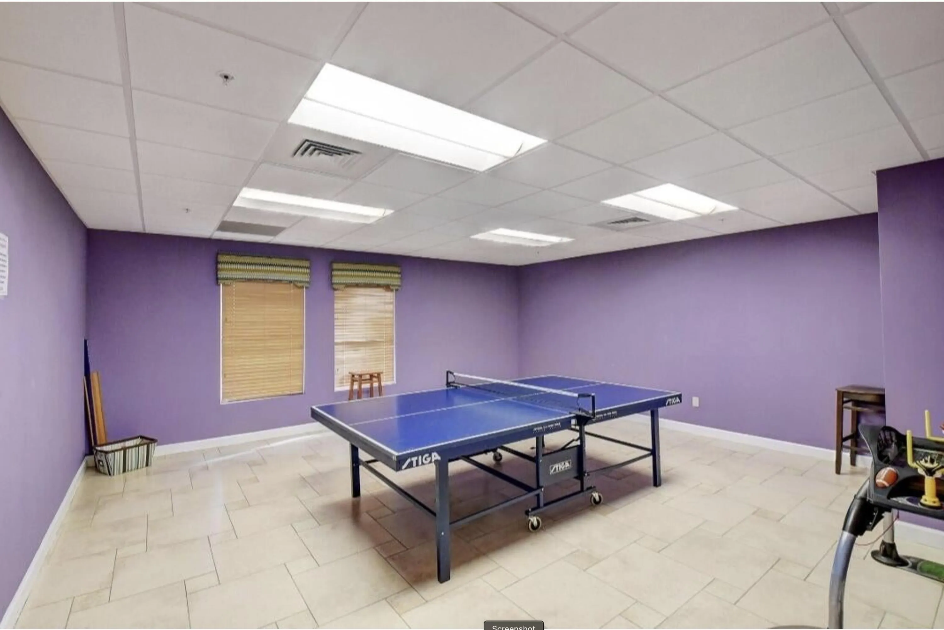 Spacious room featuring light-toned floor tiles and lavender walls