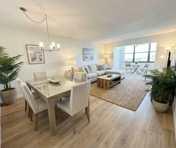 Virtually Staged Open-concept living and dining area featuring wood-finish flooring