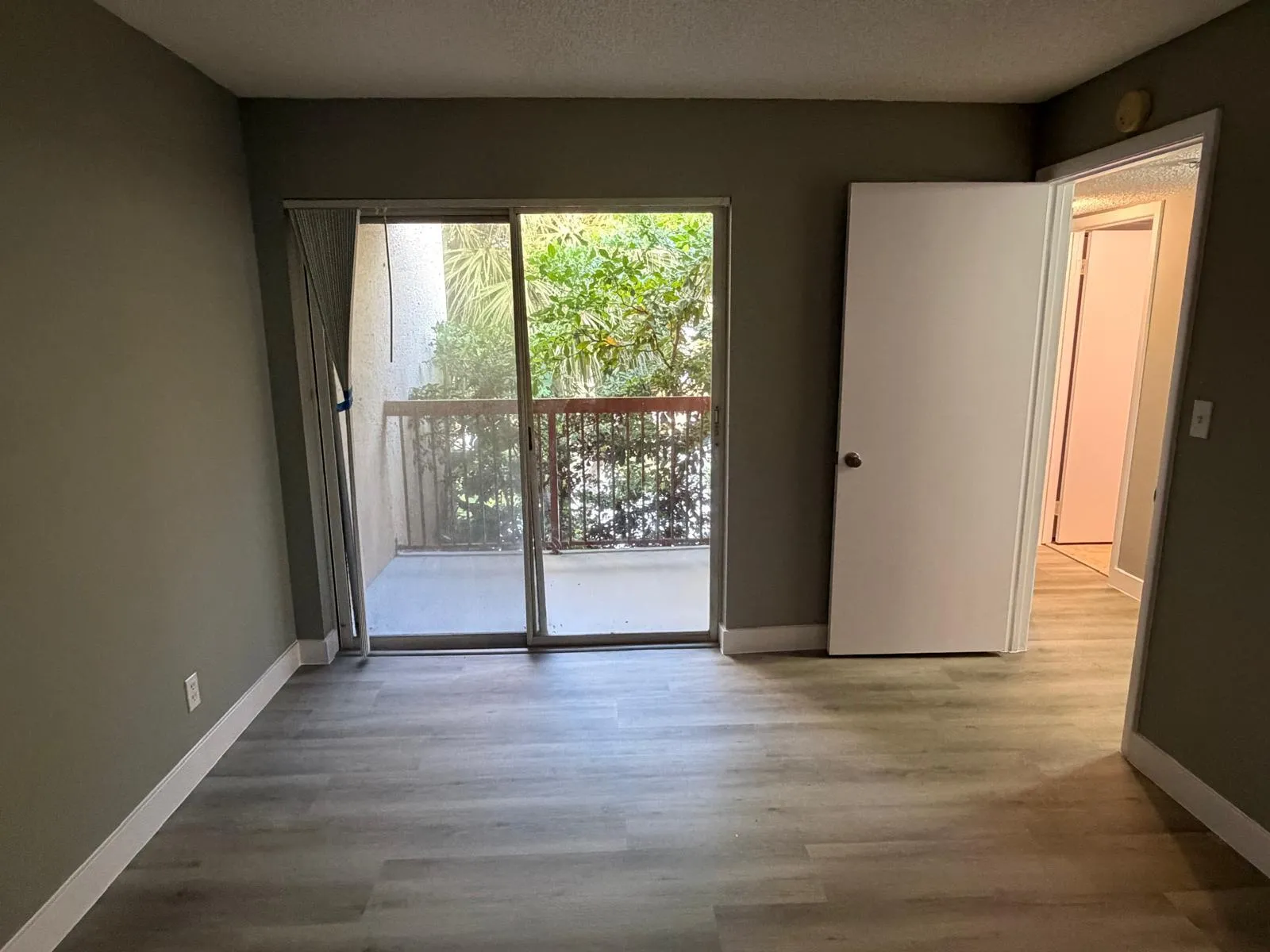 Interior space featuring wood-finish flooring, a neutral wall palette, and white baseboards