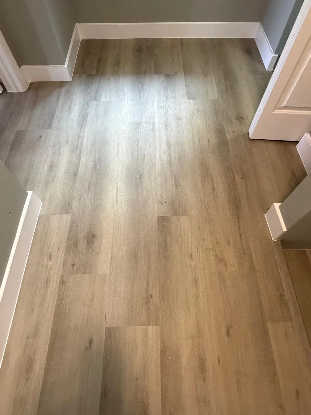 Wood-finish plank flooring throughout, complemented by crisp white baseboards and neutral wall tones