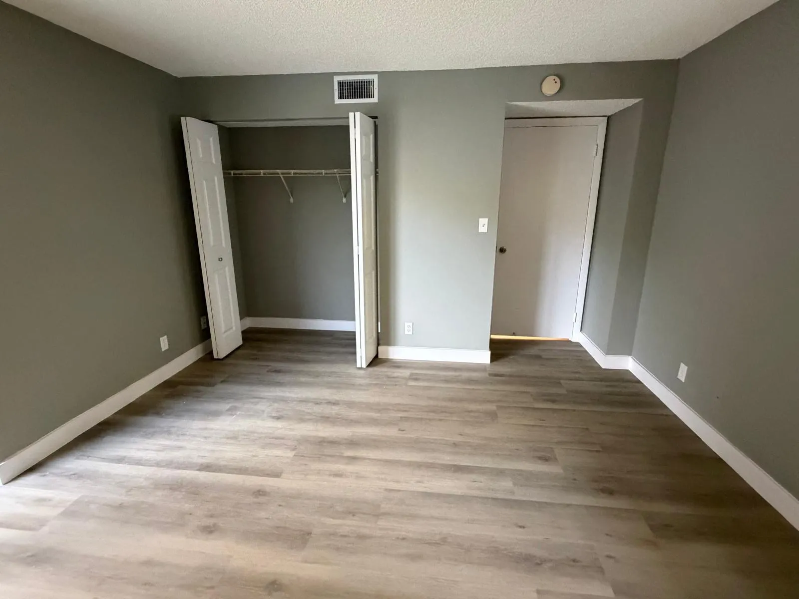 Interior room featuring wood-finish flooring, neutral wall paint, and white baseboards