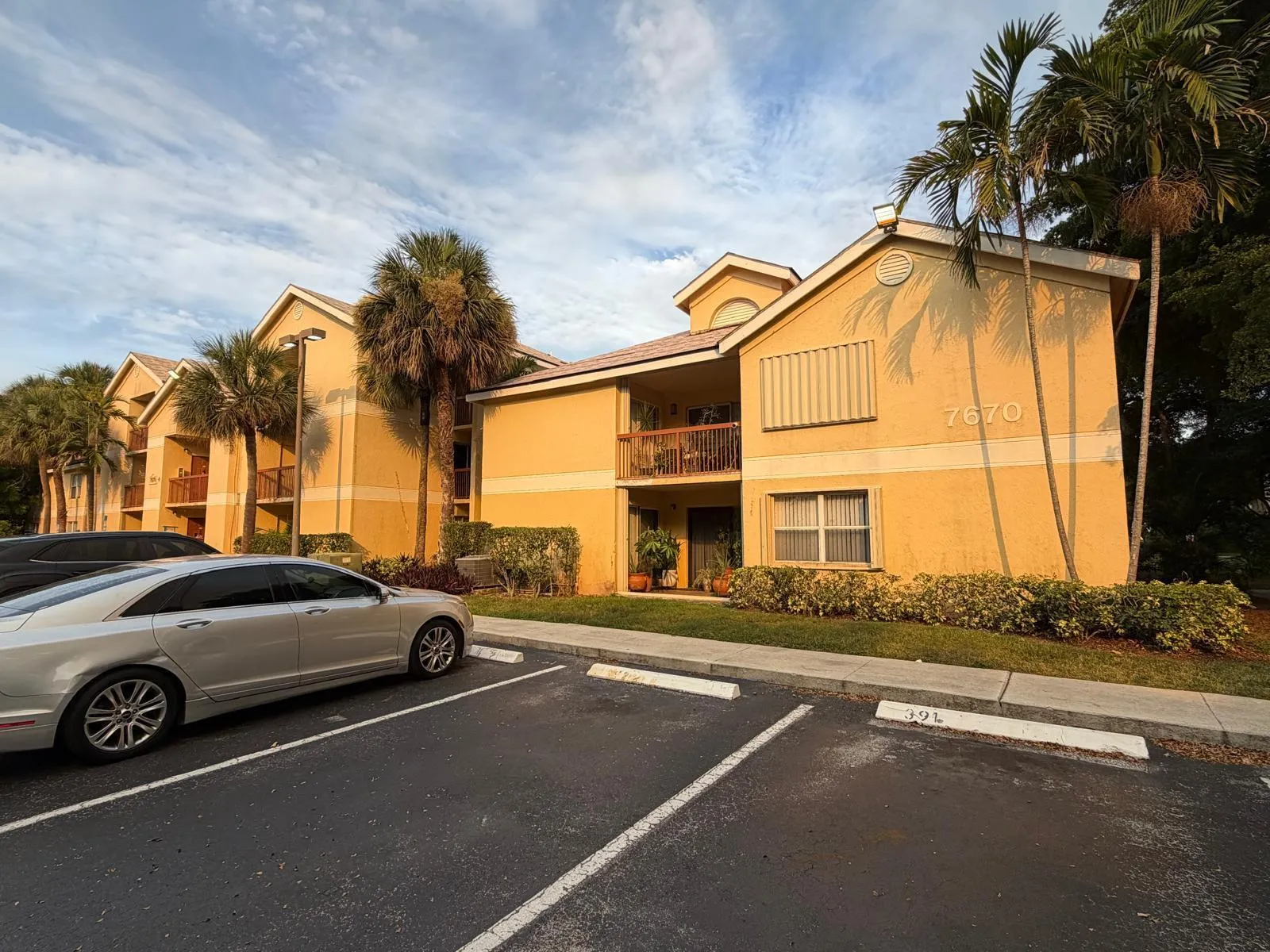 Multi-story building exterior featuring a warm yellow stucco finish and multiple balconies