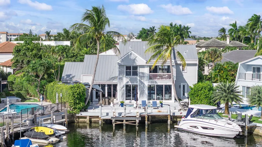 South facing pool with boat dock, boat lift, heated saltwater pool, outdoor kitchen and putting green