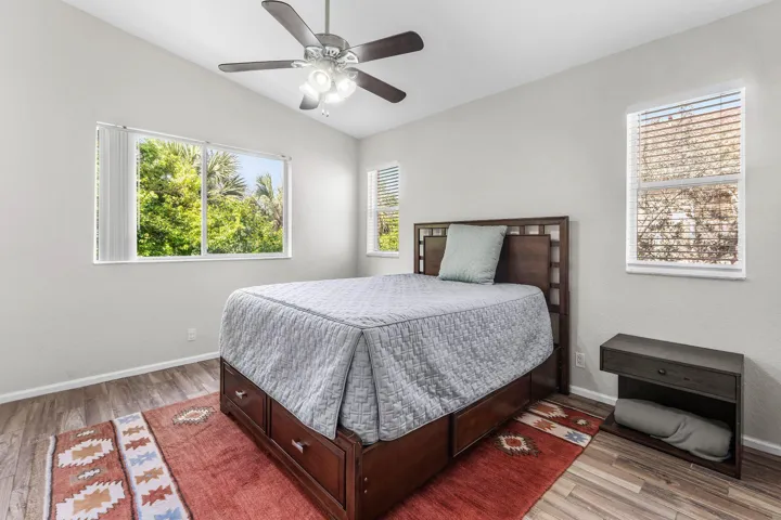 Interior room featuring high ceilings, wood-tile flooring, and multiple windows with blinds