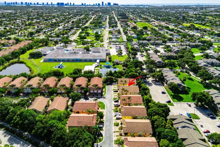 Aerial perspective showcasing a residential community with abundant green spaces and community pool.