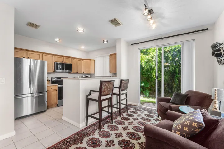 Kitchen featuring wood cabinetry, stainless steel appliances, large pantry and a breakfast bar