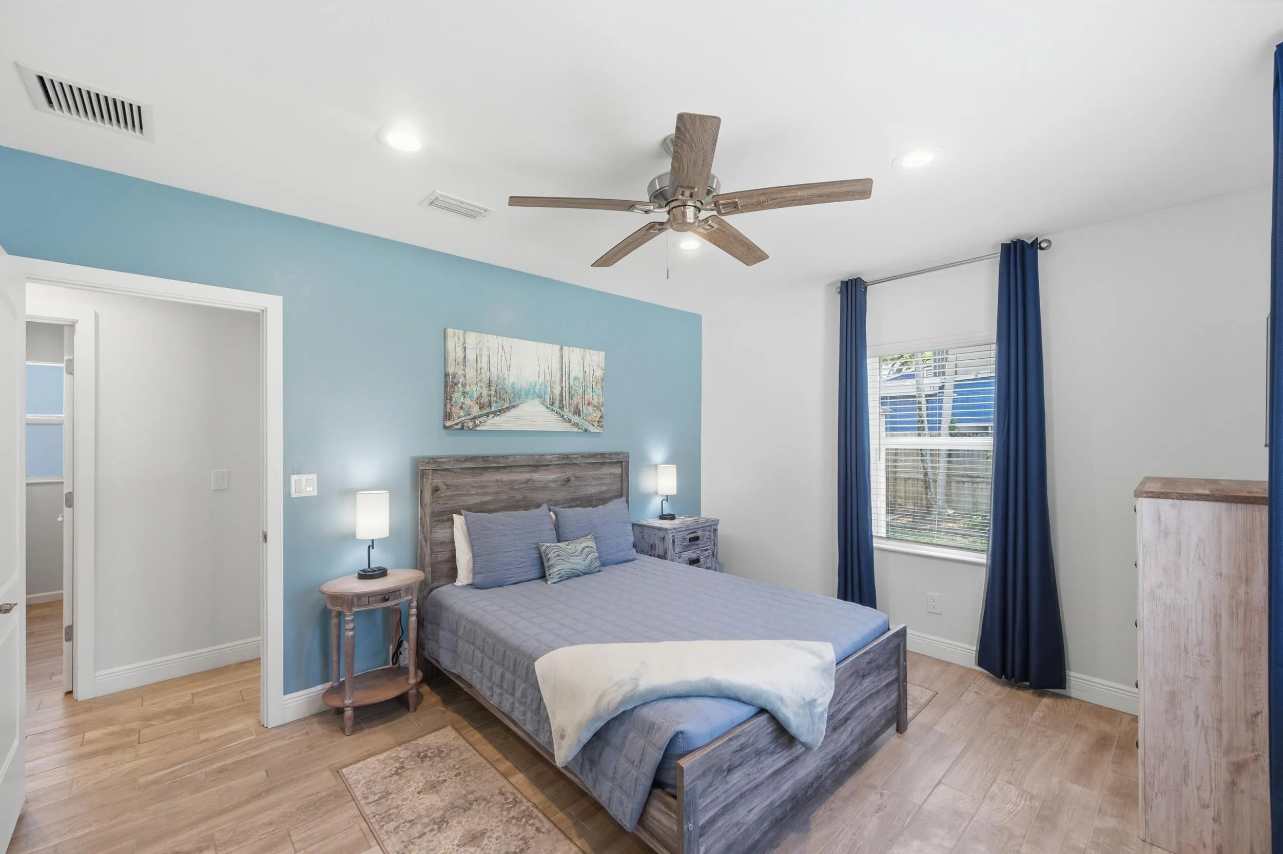 Bright room featuring two windows with white blinds, recessed lighting, a ceiling fan, and wood-finish flooring