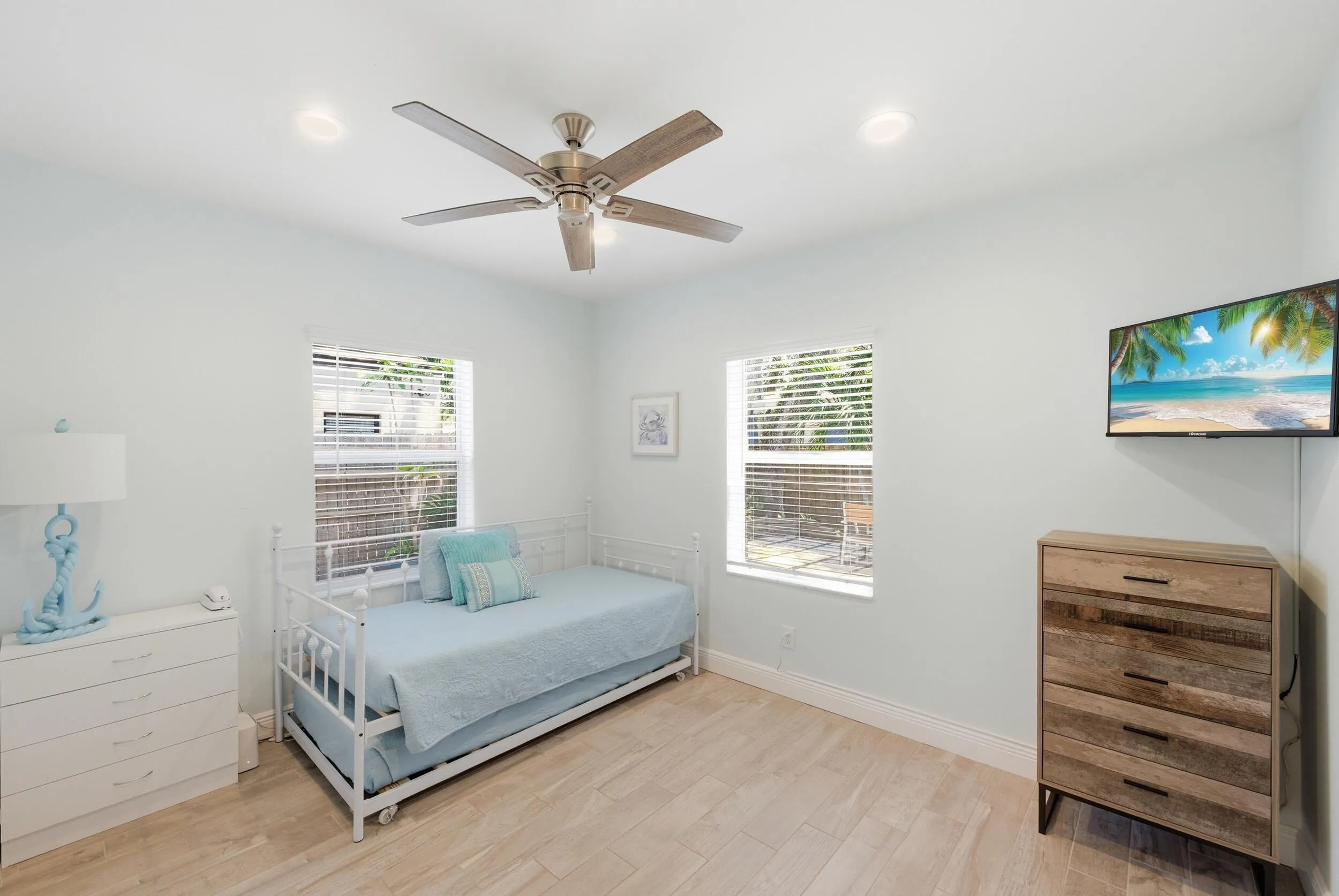 Bright room featuring two windows with white blinds, recessed lighting, a ceiling fan, and wood-finish flooring