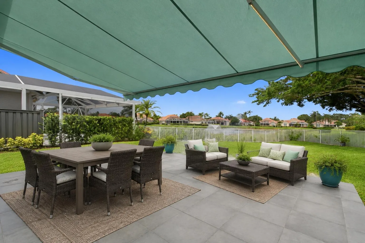 The backyard has an automatic retractable awning. Patio furniture is virtually staged