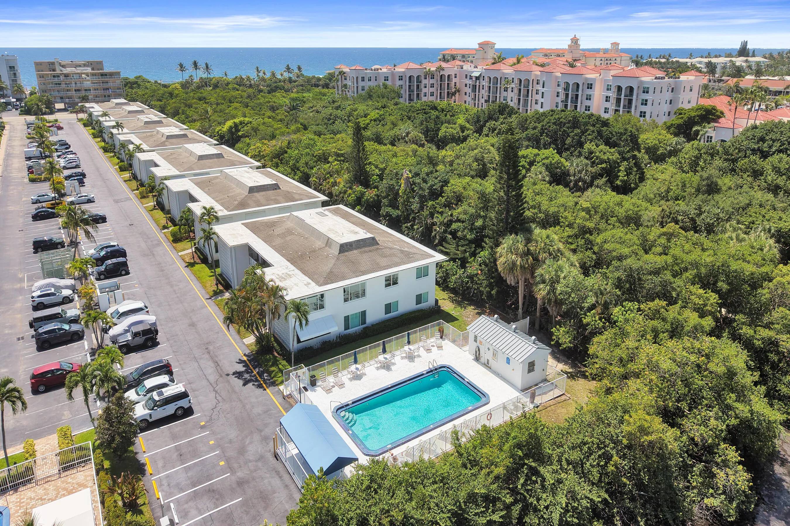 Community features include an outdoor swimming pool with a surrounding patio, a poolside building, and surface parking