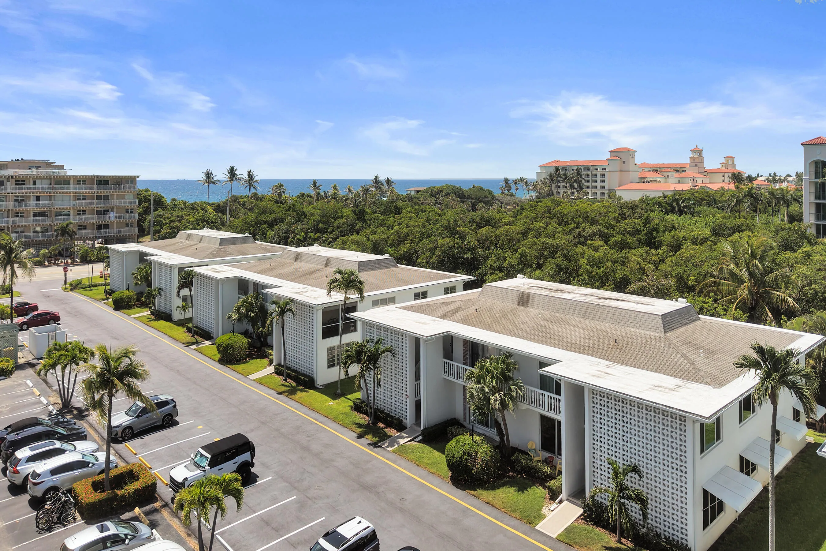 Multi-story residential buildings with balconies and a partial ocean backdrop