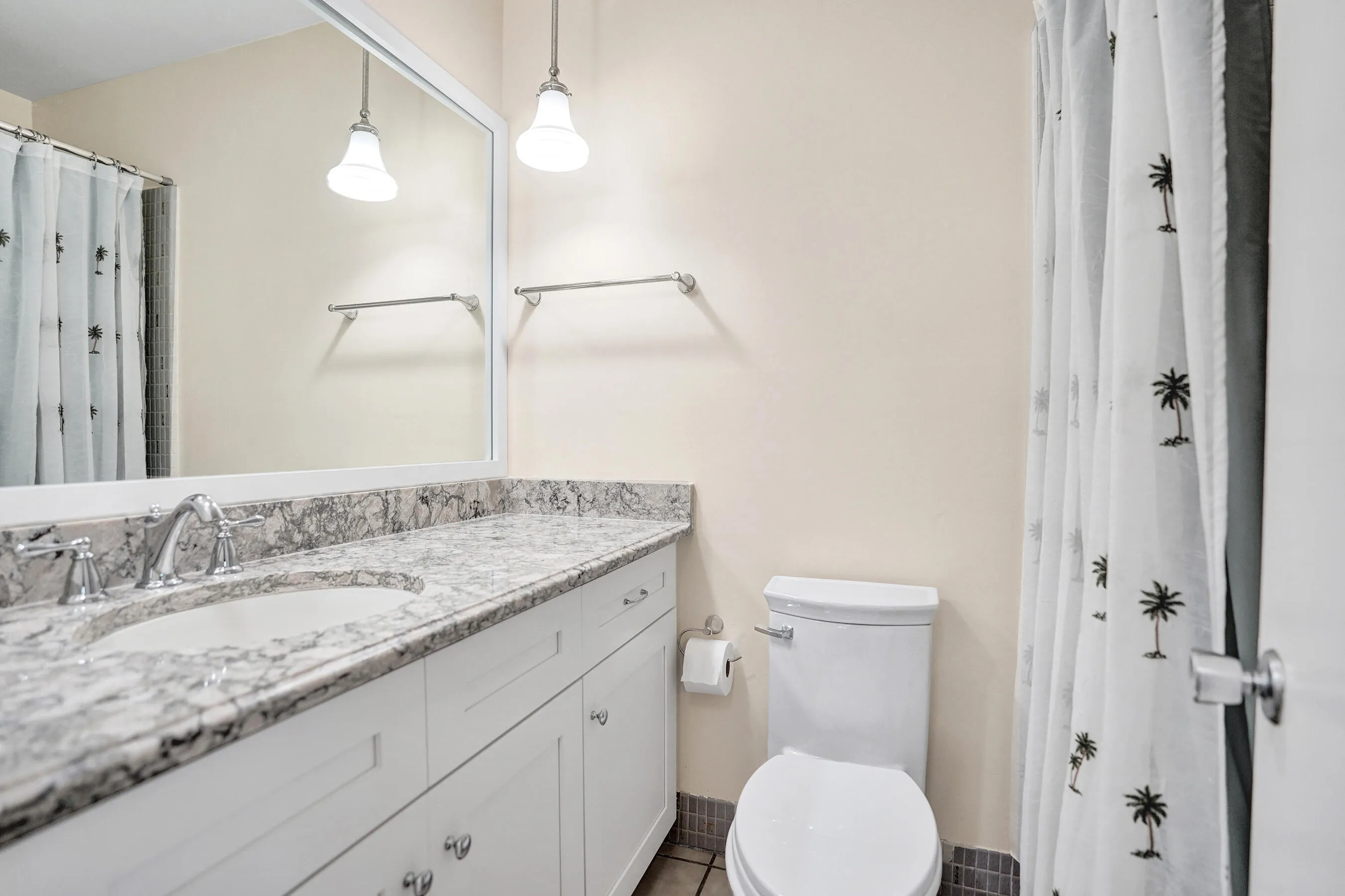Guest Bathroom featuring a double vanity with stone-finish countertop, undermount sinks, and chrome fixtures