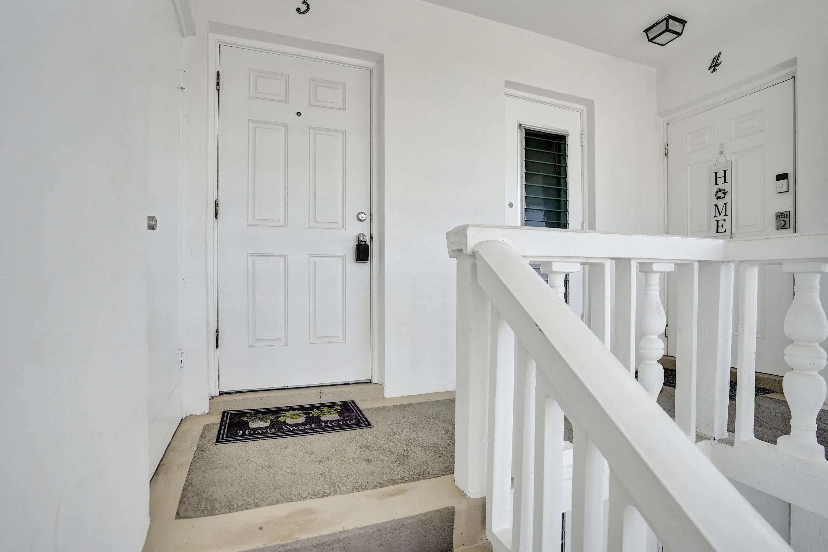 White paneled entry door with black hardware