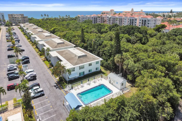 Community features include an outdoor swimming pool with a surrounding patio, a poolside building, and surface parking