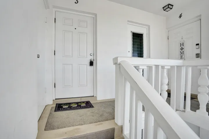 White paneled entry door with black hardware