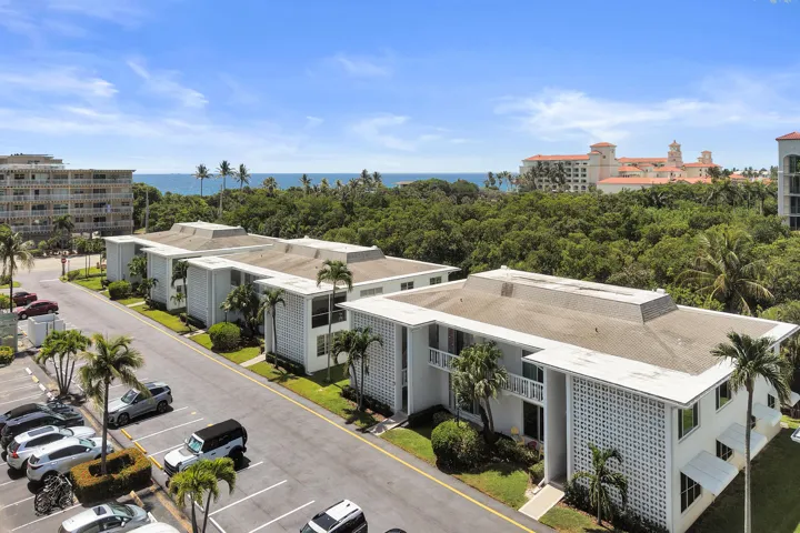 Multi-story residential buildings with balconies and a partial ocean backdrop