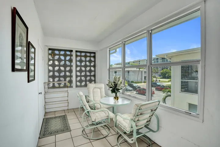 Enclosed patio featuring floor-to-ceiling glass windows, ceramic tile flooring, and a patterned privacy screen