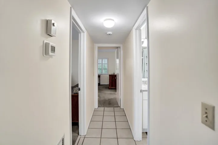 Neutral painted hallway with square tile flooring
