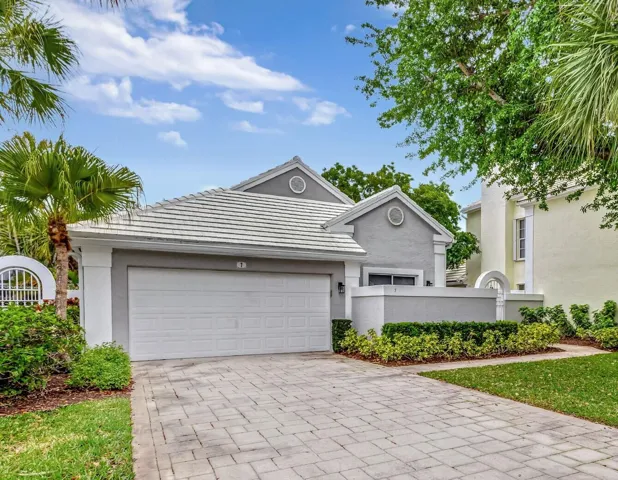 Exterior facade featuring a light gray stucco finish and white trim accents