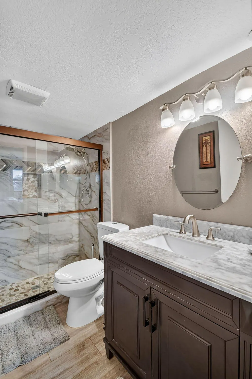 Bathroom vanity featuring a white rectangular undermount sink and a light-toned stone countertop