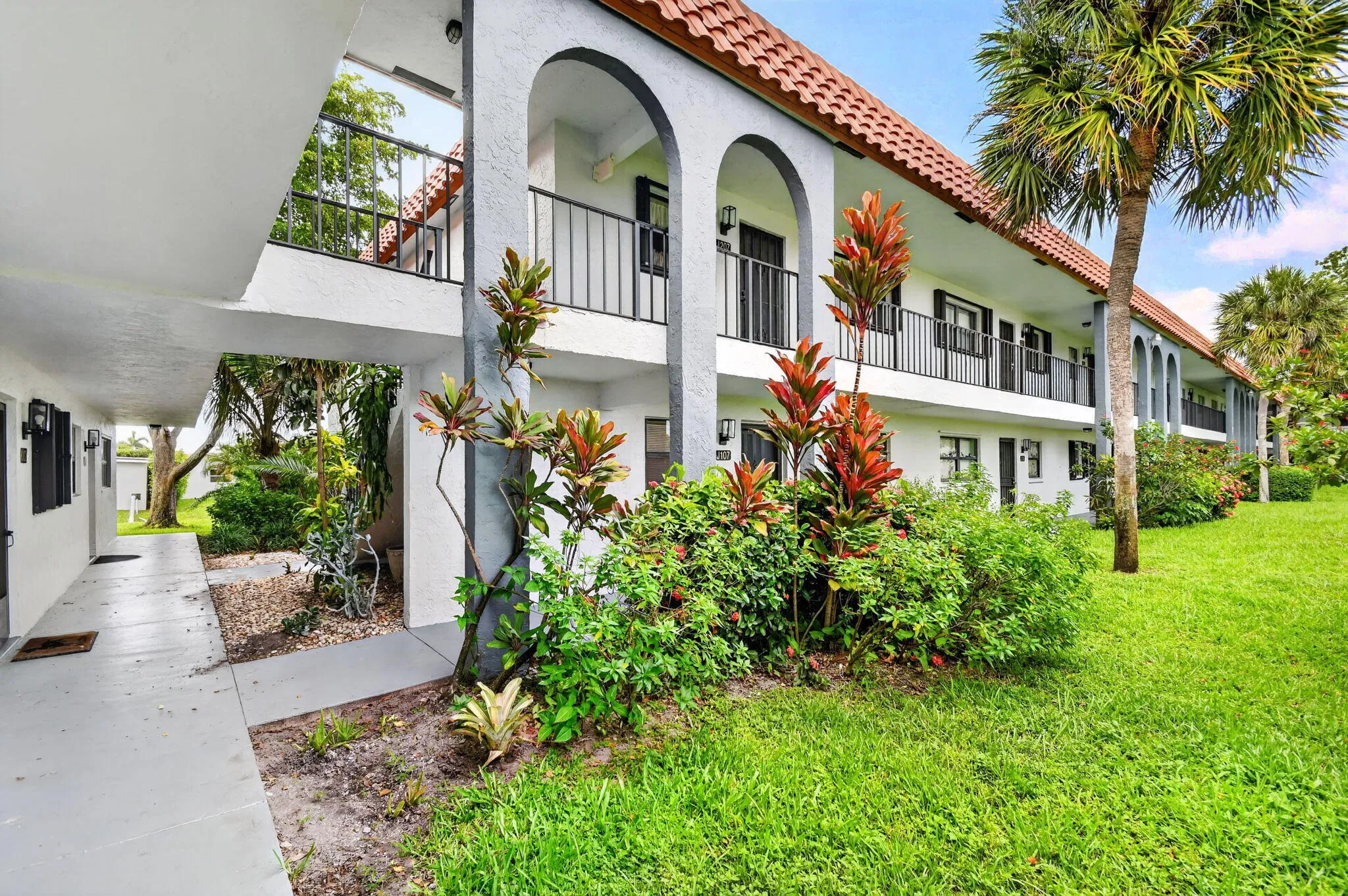 Spanish-style residential building featuring a terracotta tile roof and stucco exterior