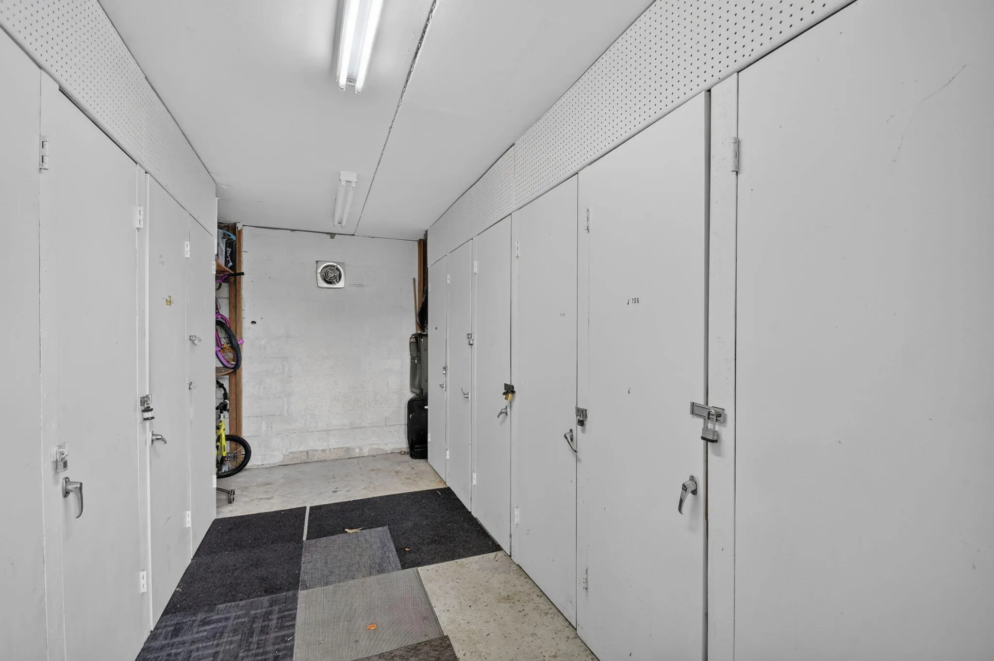 Individual storage units featuring white doors and metal latches